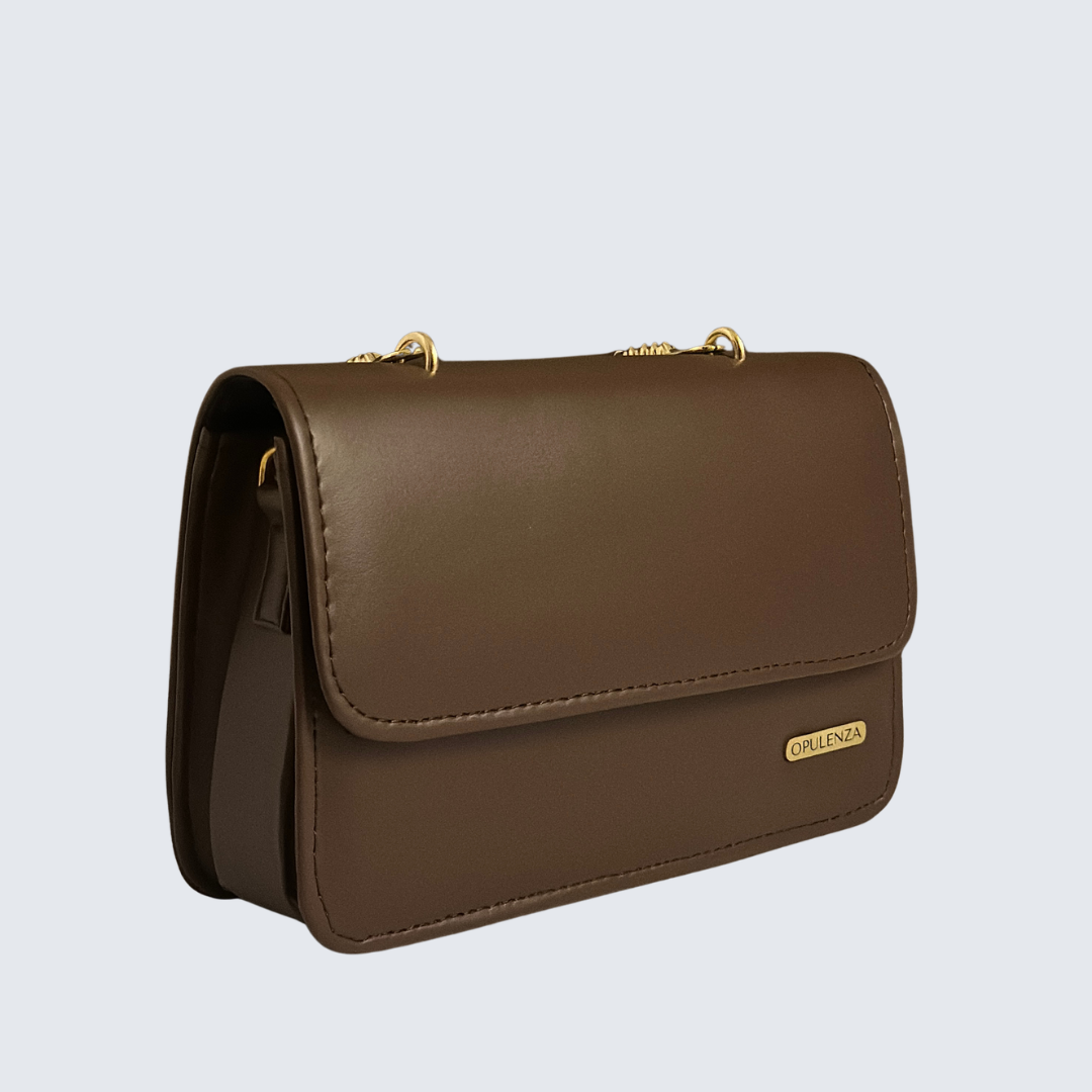 Brown leather handbag with gold accents on a light gray background